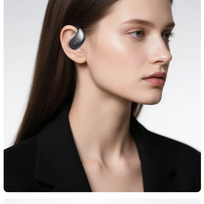 Woman wearing a black earbud with a plain background