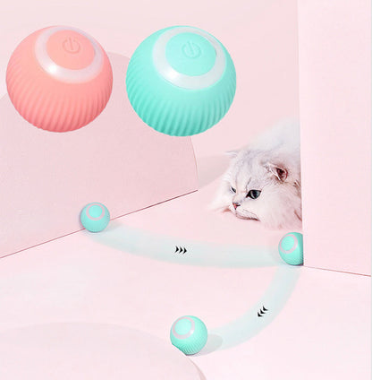 Interactive Smart Pet Ball for Cats & Dogs  in pastel pink and mint green floating above a white fluffy cat, with mint green toy balls rolling on a pink surface and a soft light trail effect.